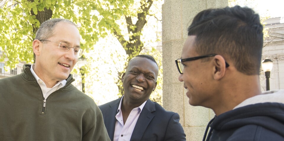 Dr. Katz talking and laughing with two men outdoors